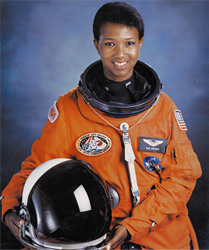 Dr. Mae Jemison in her NASA spacesuit and holding her helmet