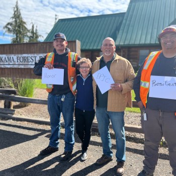 Christian Hansen (left), President Mary C. Daly, Steve Rigdon (center), and Michael Hogarty (right) display their one word descriptions of Yakama Nation. The one word descriptions are Honor, Epic, and Resilient, respectively.