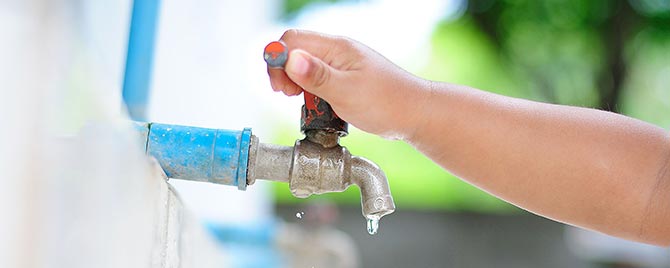 Child Adjusts Faucet