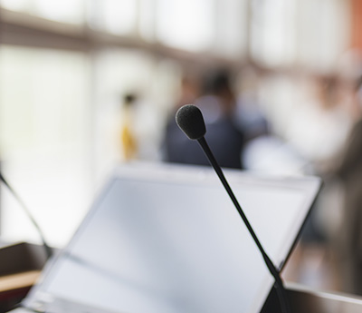 Background image of a board room, focus on the lectern microphone