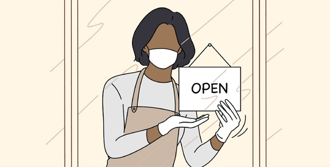 Woman inside of a shop holding up an 'OPEN' sign