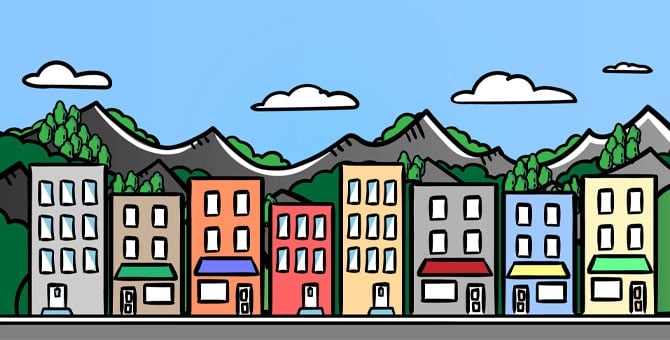 Buildings with a background of mountains, trees, and a blue sky with a few clouds