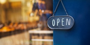 A sign that reads "OPEN" next to a store window