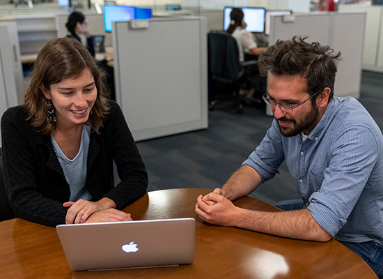 Aina and Jacob Weber, an SF Fed Dissertation Fellow, go over information on a computer