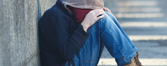 Young man sitting on path