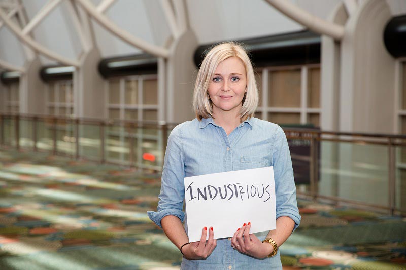 Meg Walter holds sign reading Industrious