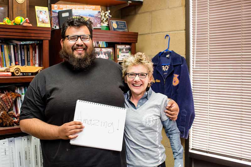 Mr. Sanchez, with President Daly, holds sign reading Amazing