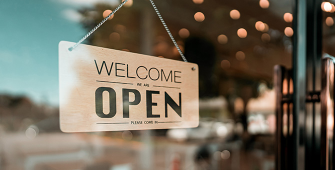 Open sign board on glass door.