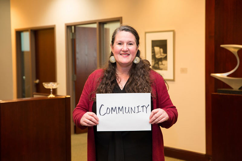 Robbyn Scribner holds sign reading Community