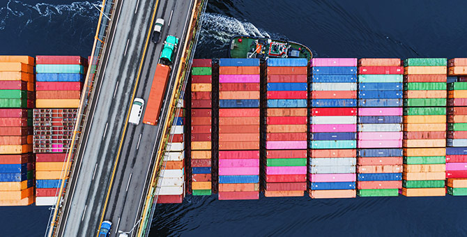 Container ship passing beneath a suspension bridge