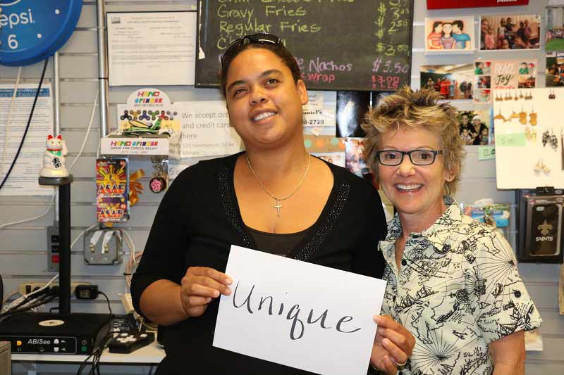 Shantel Jones, with President Daly, holds sign reading Unique