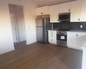 Interior of an ADU with wood floors and new kitchen appliances.