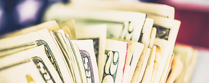 Photo of United States currency in front of American flag