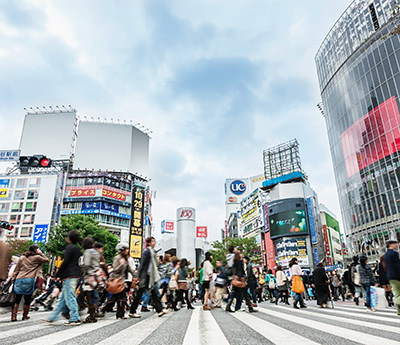 Crowd of People during rush hour walking over zebra crossing at Shibuya Station in Downtown Tokyo. Motion Blurred People. Tokyo, Japan.